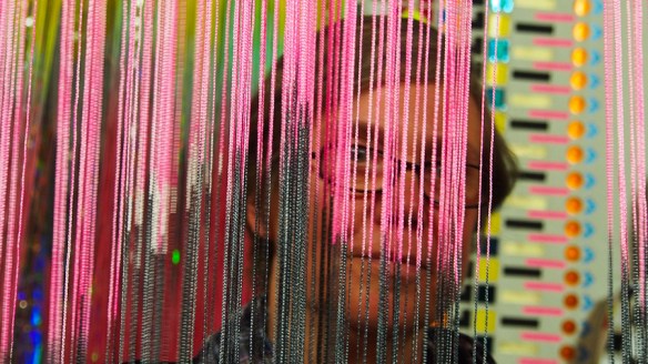 Frau hinter buntem Vorhang