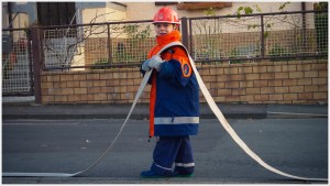 Jugendfeuerwehrmann mit Schlauch