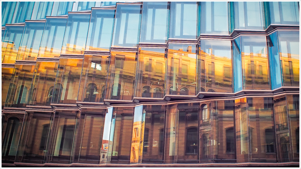 Ein Gebäude spiegelt sich in einer Glasfassade