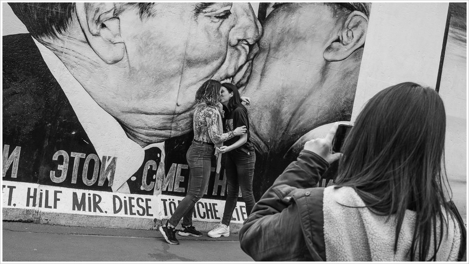 Zwei Mädchen küssen sich vor Bild der East-Side Gallery