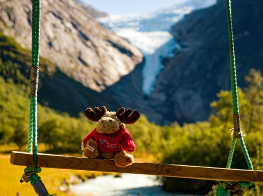 Elchfigur auf Schaukel vor Gletscher