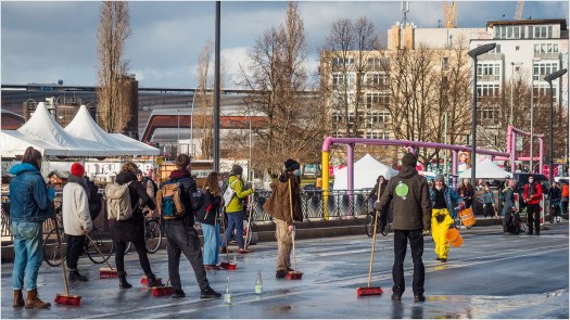 Menschen mit Besen auf der Straße