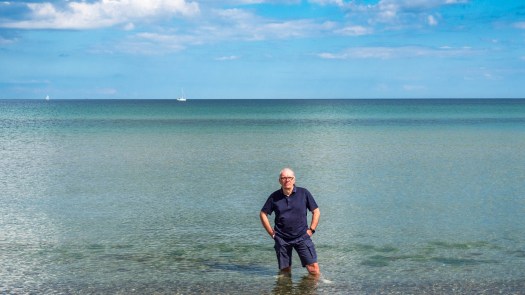 Eine Person steht bis zu den Knien im Meer