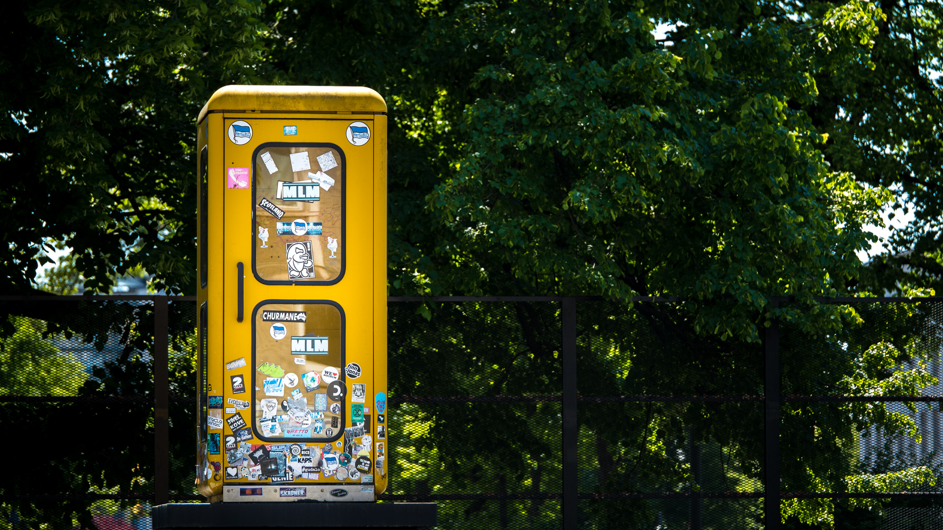 Gelbe Telefonzelle auf Sockel