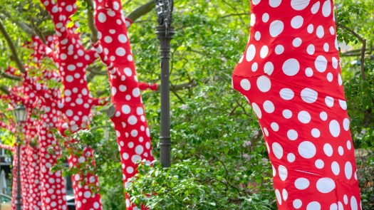 Bäume umhüllt von rotem Stoff mit weißen Punkten