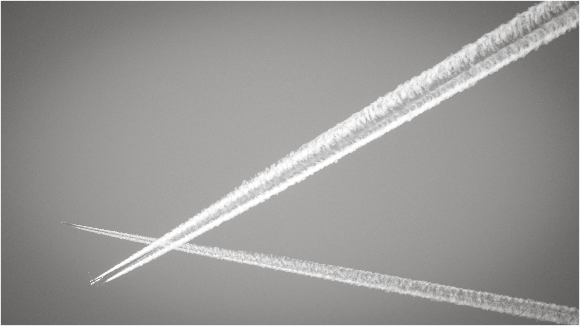 Flugzeuge mit Kondensstreifen bilden ein Kreuz am Himmel