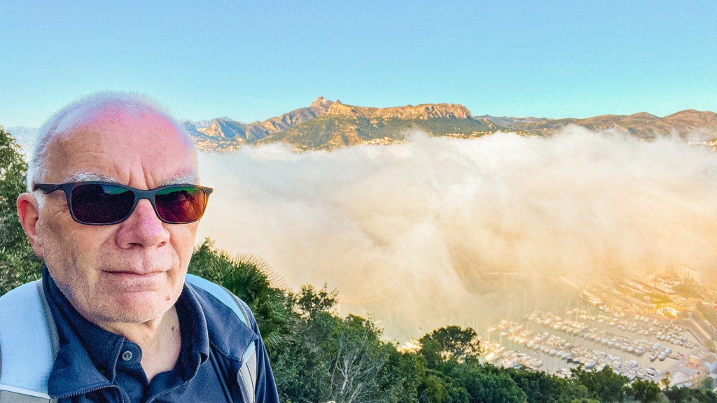 Person vor Blick auf einen Ort mit Nebel