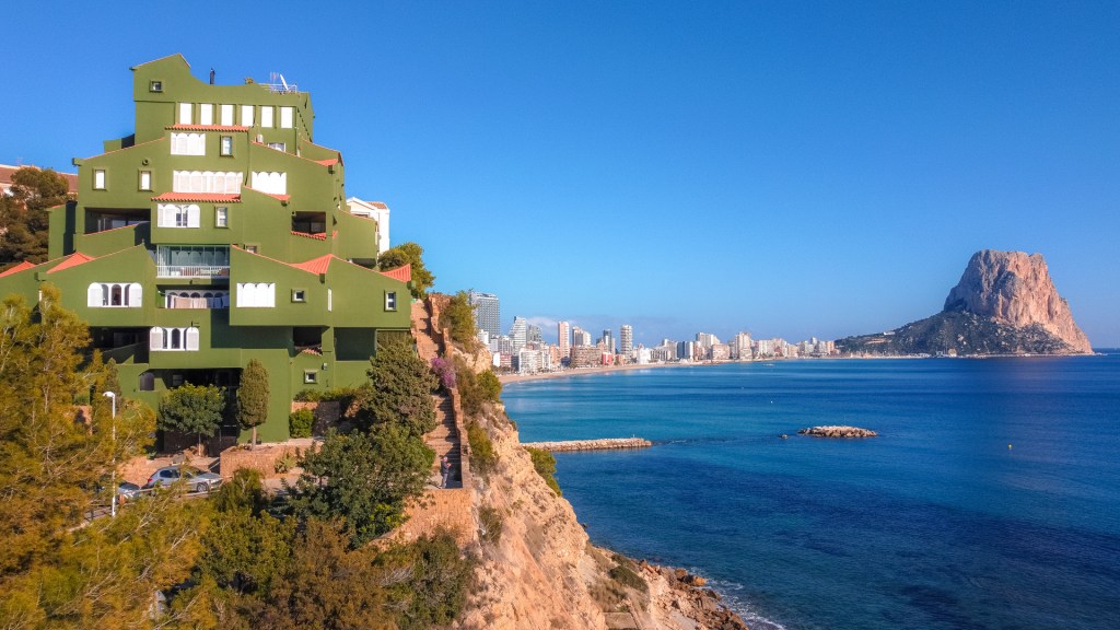 Ein grünes Gebäude auf einer Klippe in Calpe