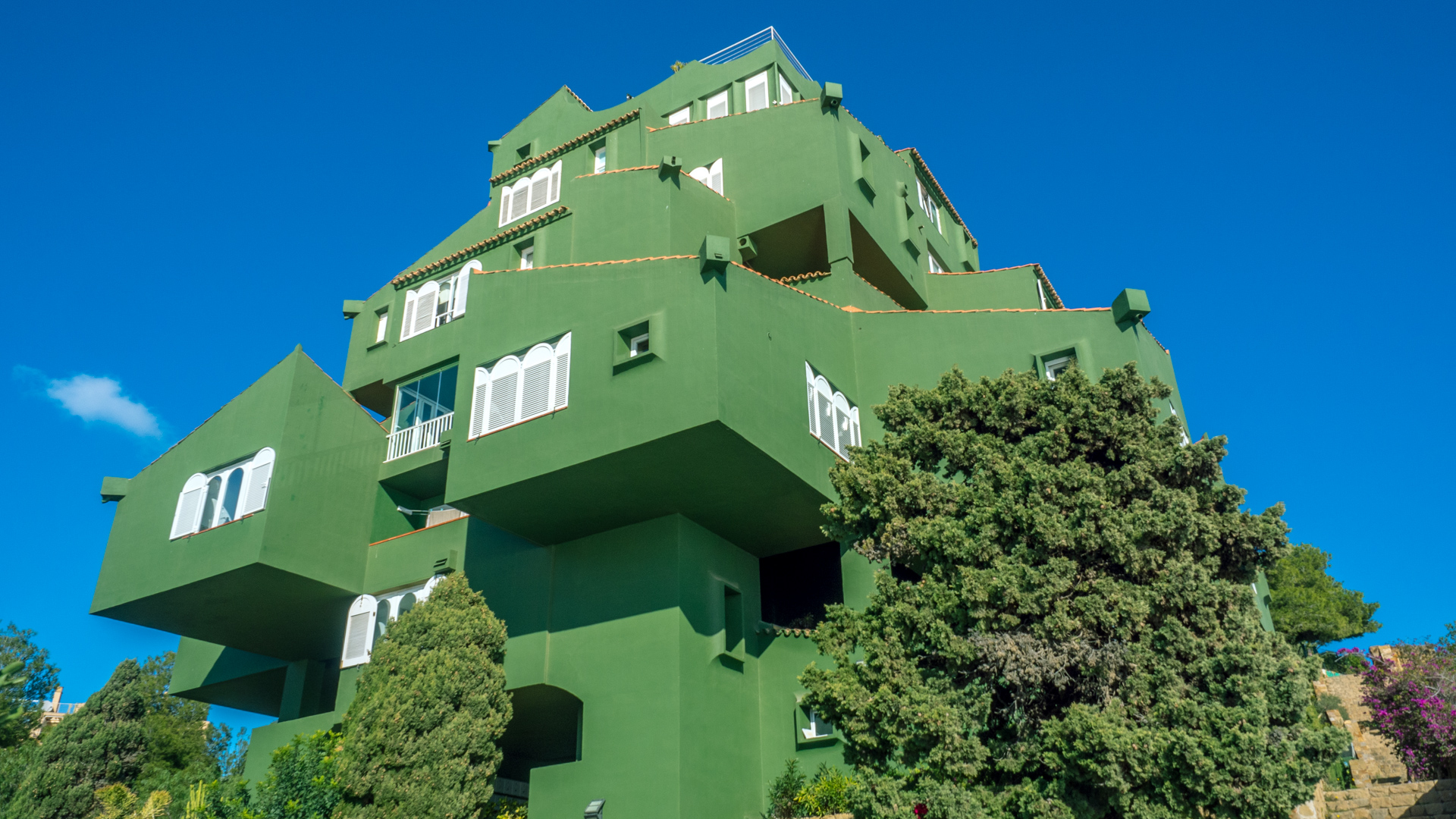 Ein grünes Gebäude auf einer Klippe in Calpe