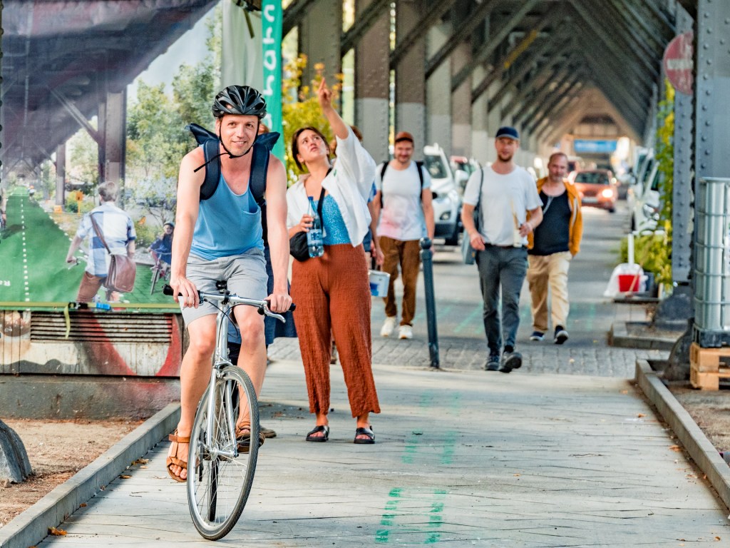 Radfahrer, Fußgänger und Autos unter dem U1 Viadukt