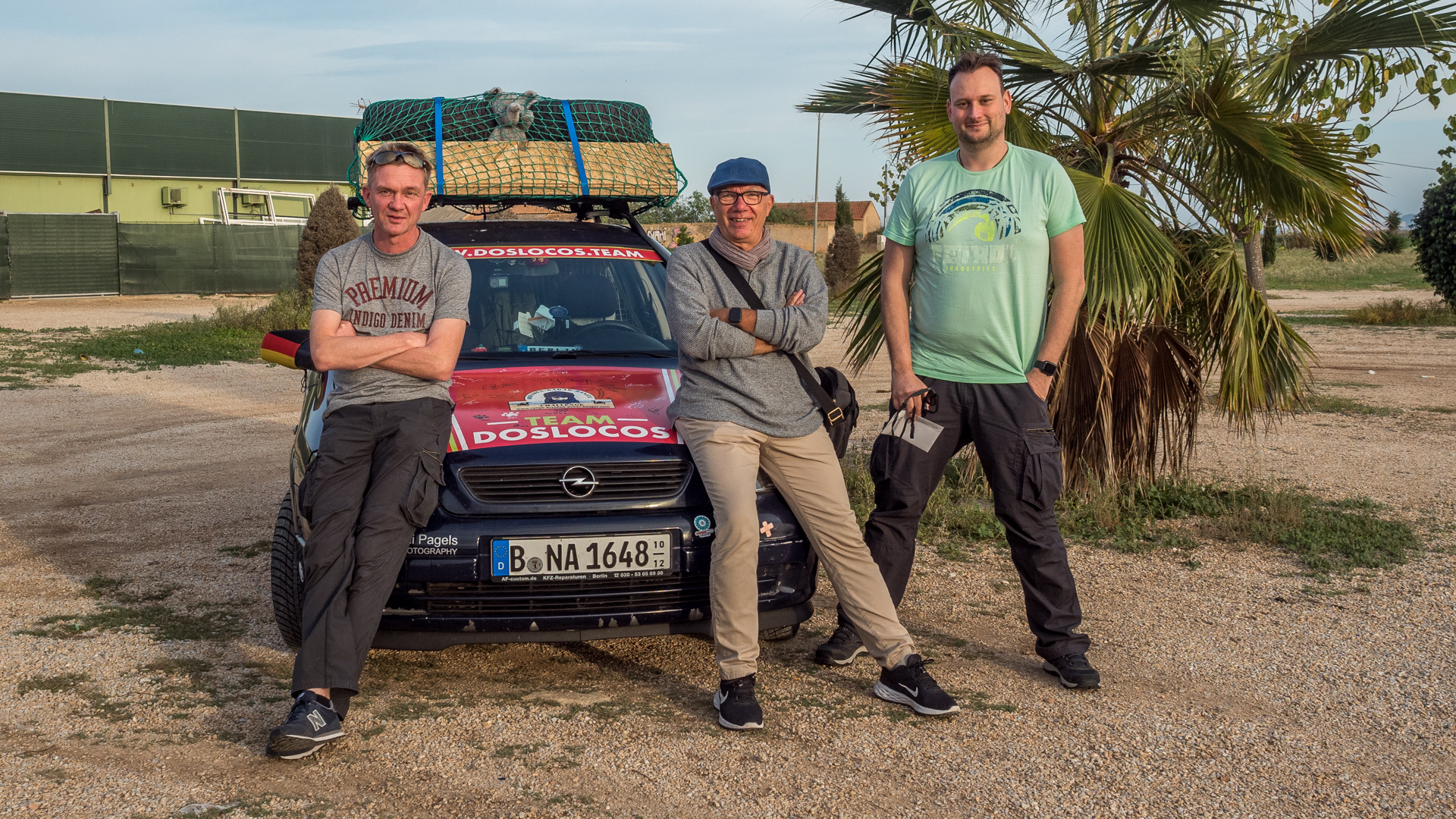 Drei Männer vor einem Auto