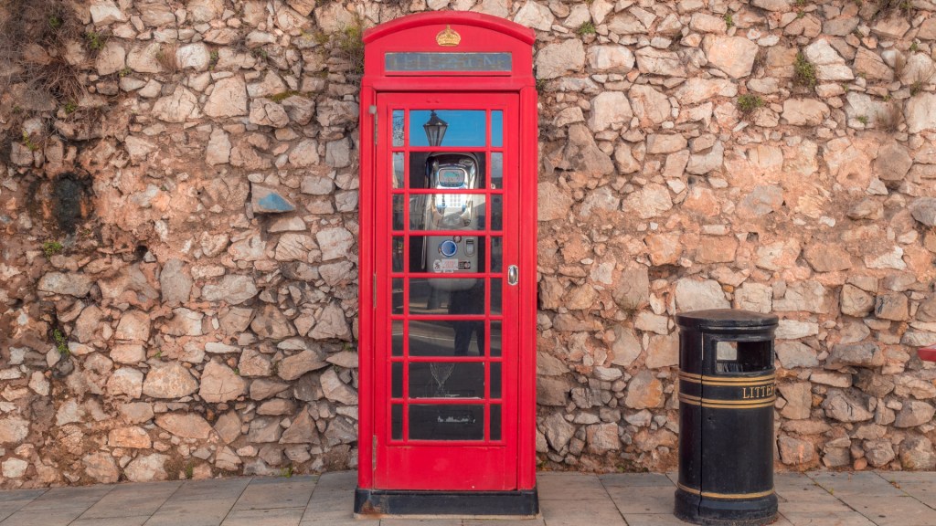 Ein Foto einer roten Telefonzelle und eines Mülleimers