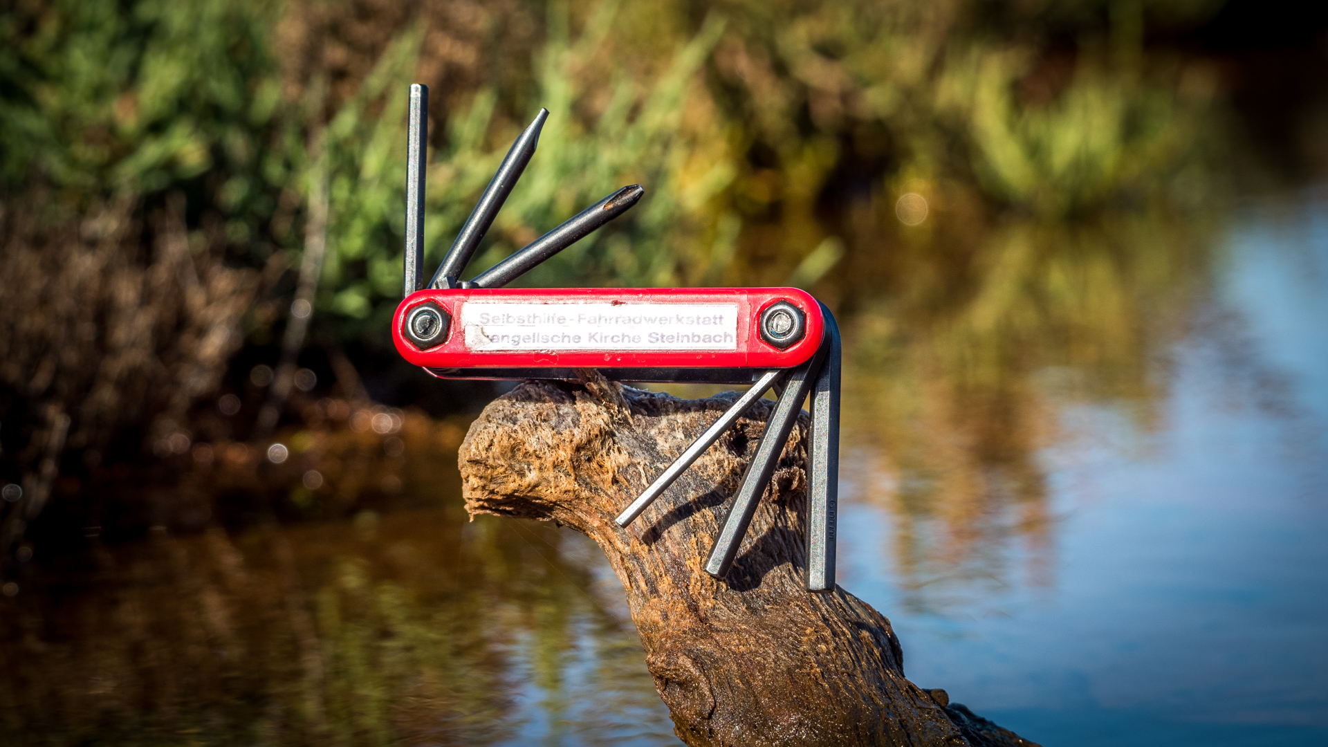 Ein Werkzeug für Fahrräder steht auf einem Ast über Wasser