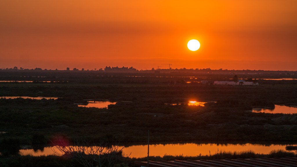 Einen Sonnenuntergang spiegelt sich in den Teichen eines Naturparks in Spanien