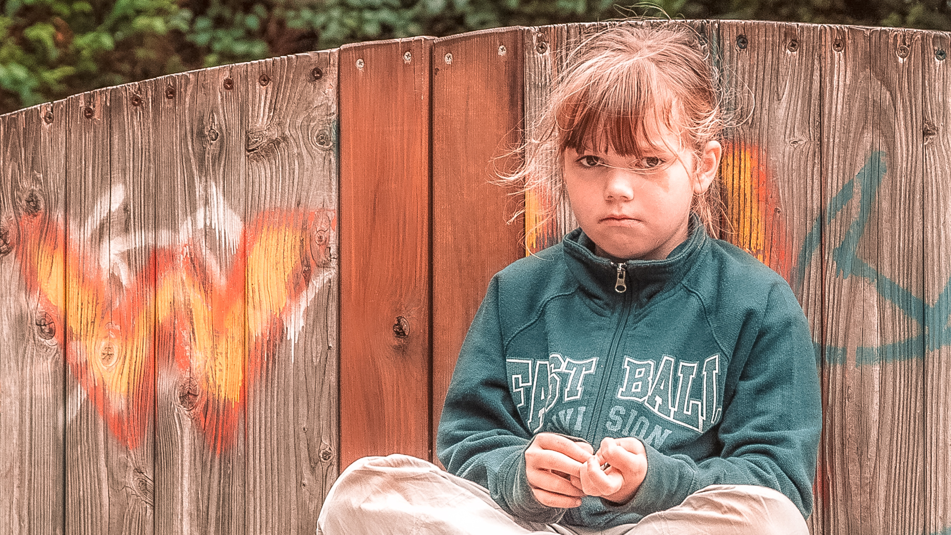 Ein junges Mädchen vor einer Holzwand