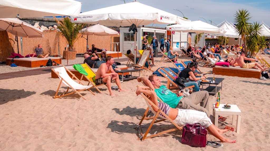 Menschen in Liegestühlen auf Sand, Beachbar in Berlin