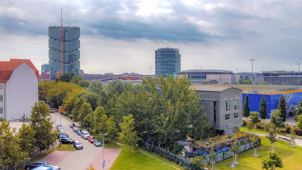 Blick von oben auf alten Lokschuppen mit Grünzug. Im Hintergrund ist der Amazon-Tower EDGE zu sehen.
