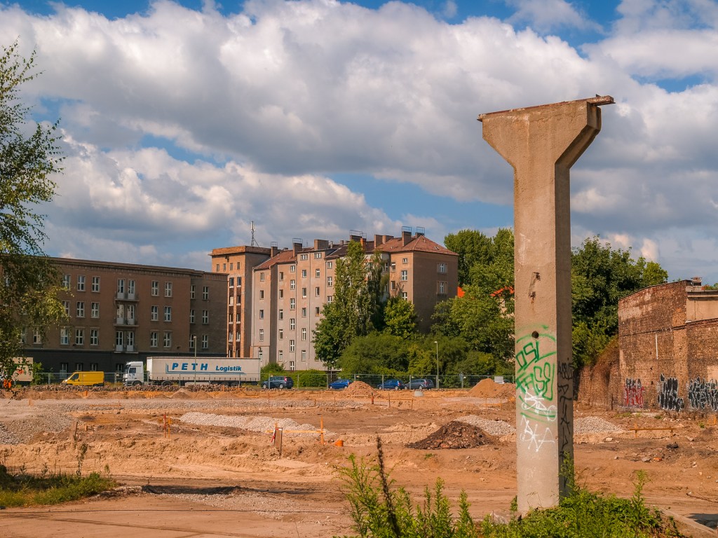 Ein alter Betonpfosten vor einem Gelände im Umbau