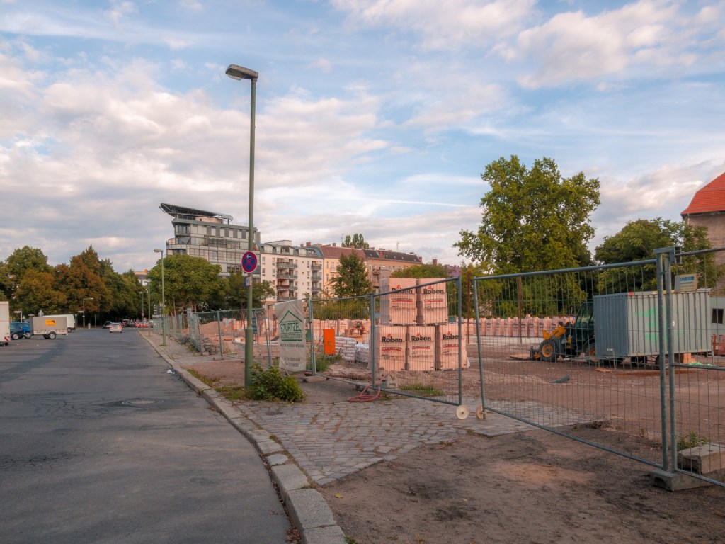 Eine Straße und ein Gelände wo Baumaterial lagert