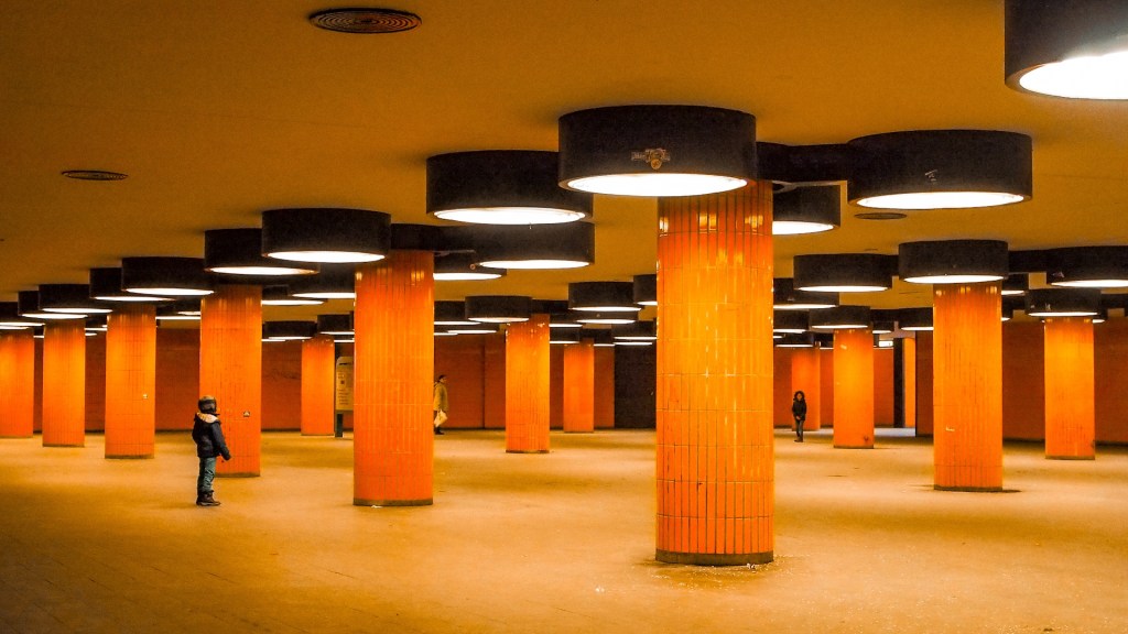 Großer Raum mit orangen Kacheln verkleideten Säulen. Durchgang zum ICC in Berlin