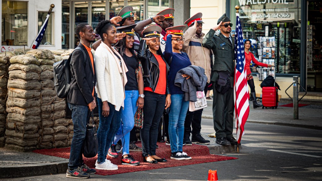 Personen lassen sich am Checkpoint Charly fotografieren