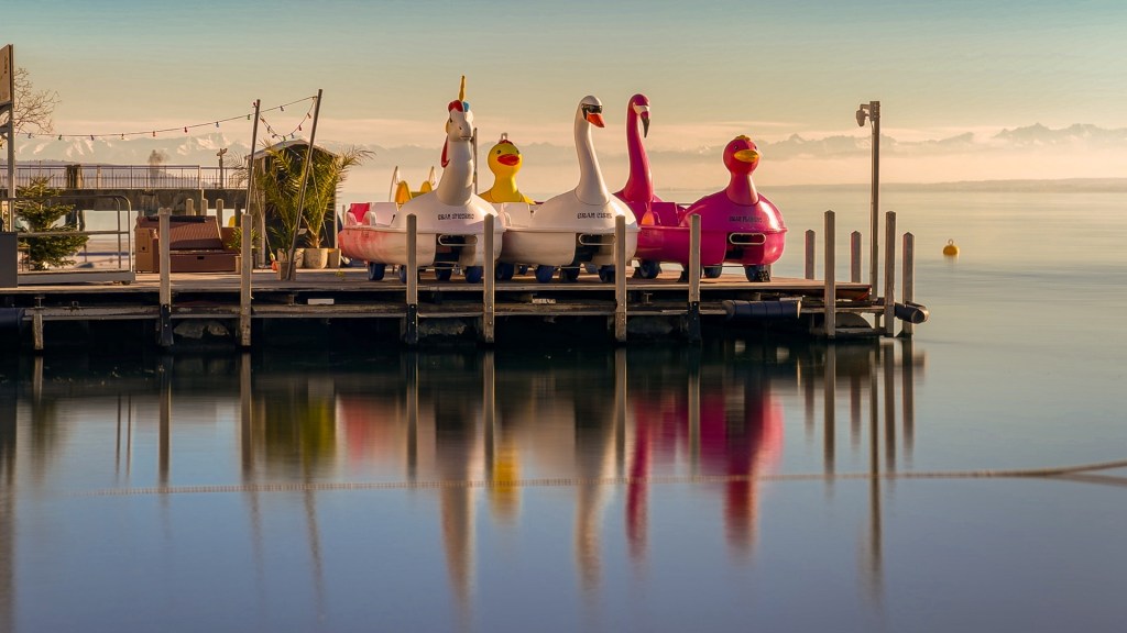 Auf einem Anlegesteg warten verschieden Boote in Form von Einhorn, Schwan und Flamingo auf den Frühling