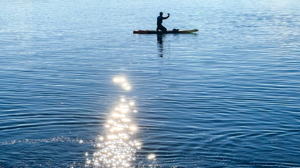 Ein SUP Fahrer macht ein Selfie auf seinem Bord