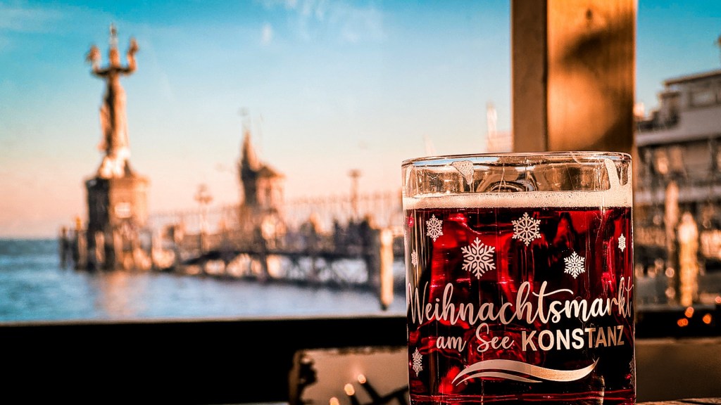 Ein Glühweinbecher aus Glas. im Hintergrund unscharf die Imperia