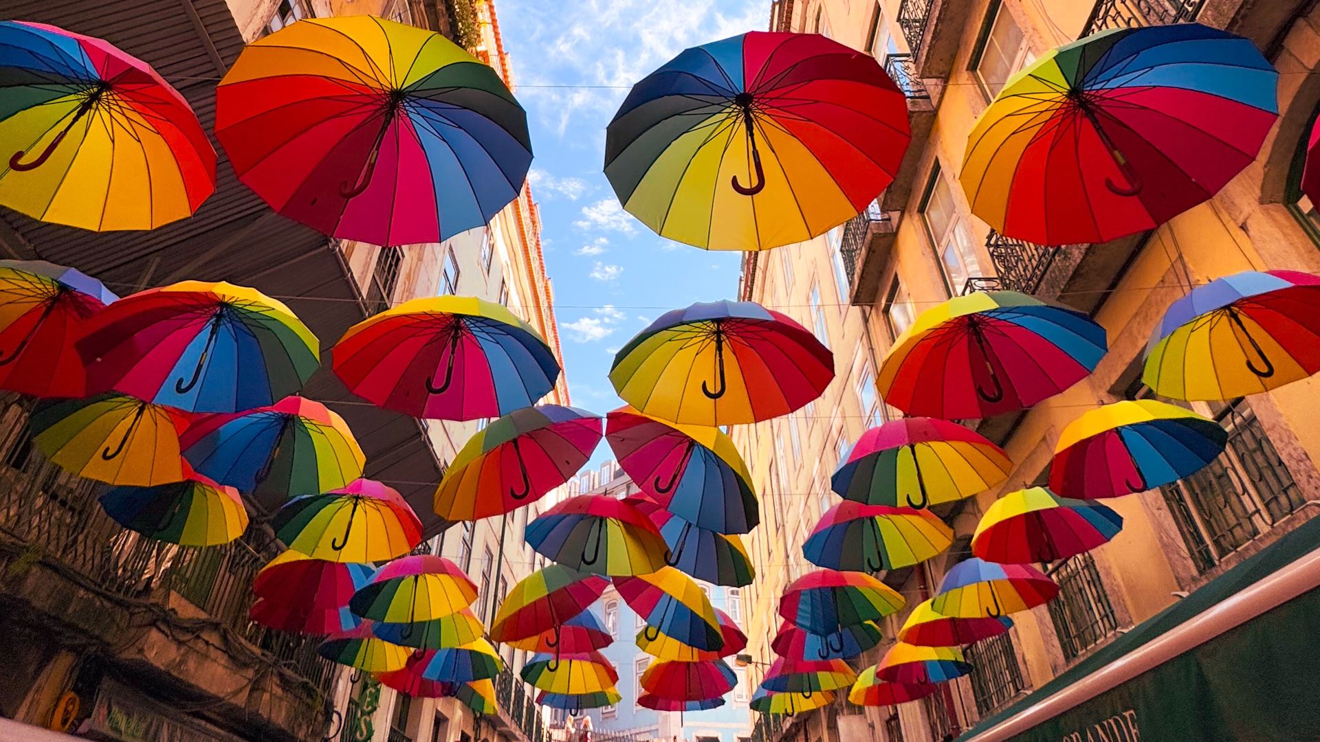 Bunte Regenschirme über der Pink Lane in Lissabon