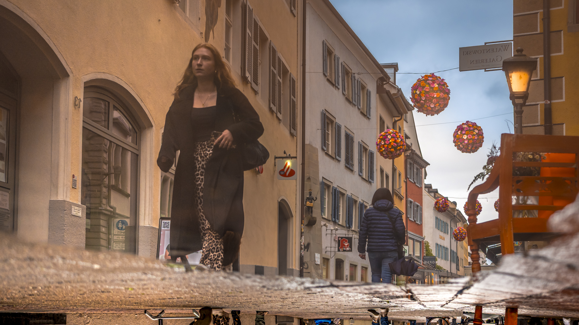 Straßenszene in Konstanz. Foto ist über eine Pfütze gespiegelt.