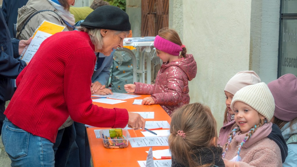 Kinder an einem Tisch lösen Aufgaben bei der Kinderolympiade in Überlingen.