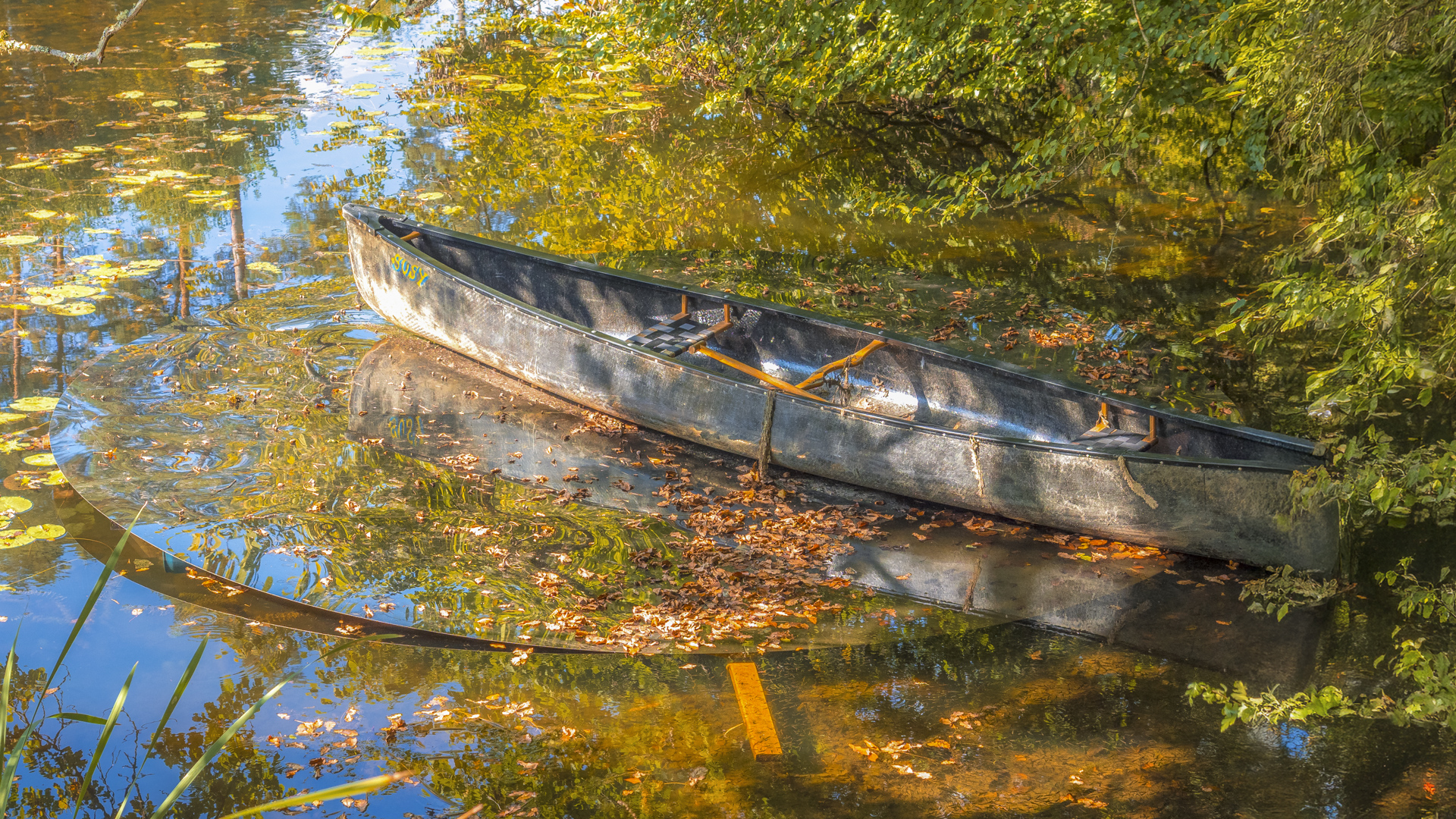 Ein Kanu steht auf einer runden Spiegelfläche, die im Wasser liegt.