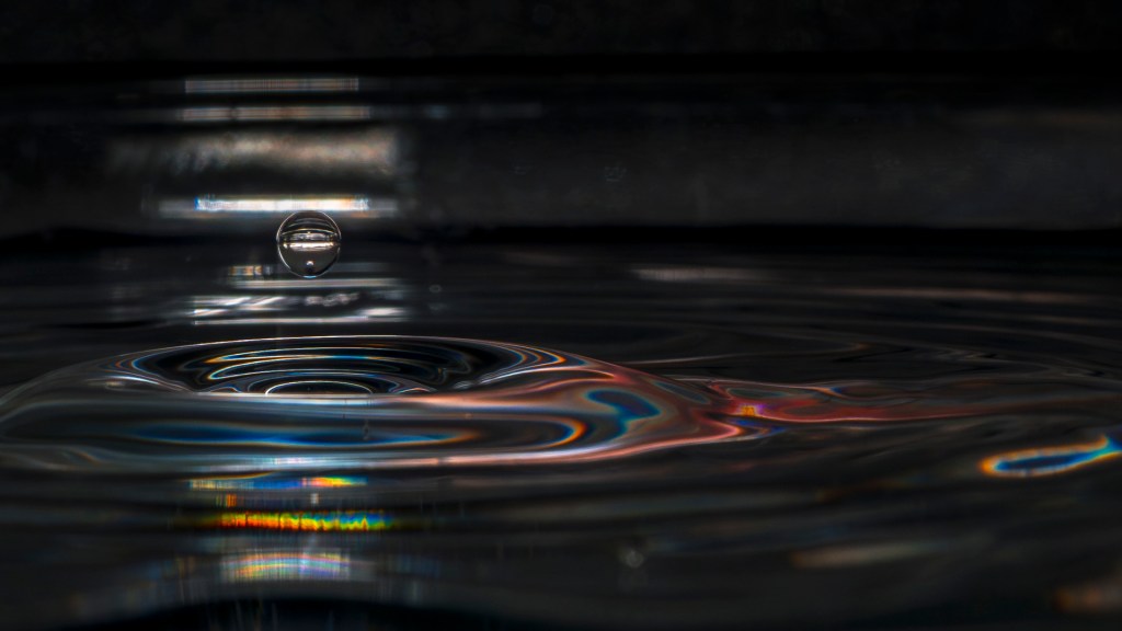 Wassertropfen springen aus Wasseroberfläche