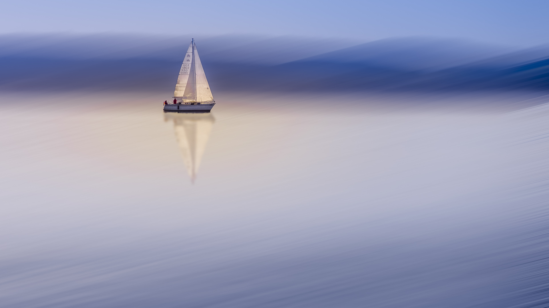 Ein Segelboot auf einem See, verfremdet durch Bewegungsunschärfe (Adamski-Effekt)