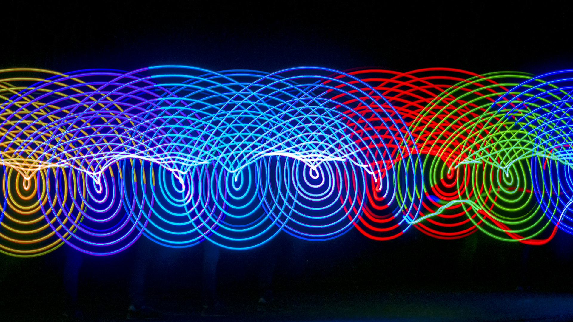 Ein Lightpainting zeigt zwei verschiedenfarbene Lichtspuren die mit unterschiedlichen Objekten erzeugt wurden.