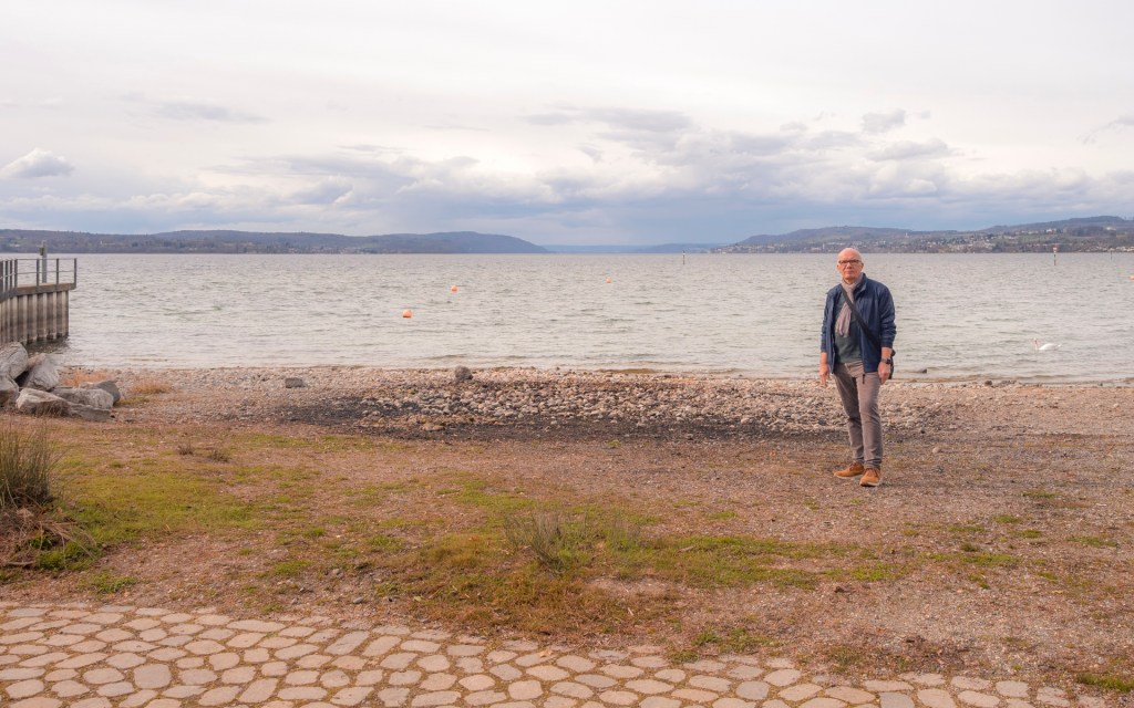 Eine Person steht an einem See