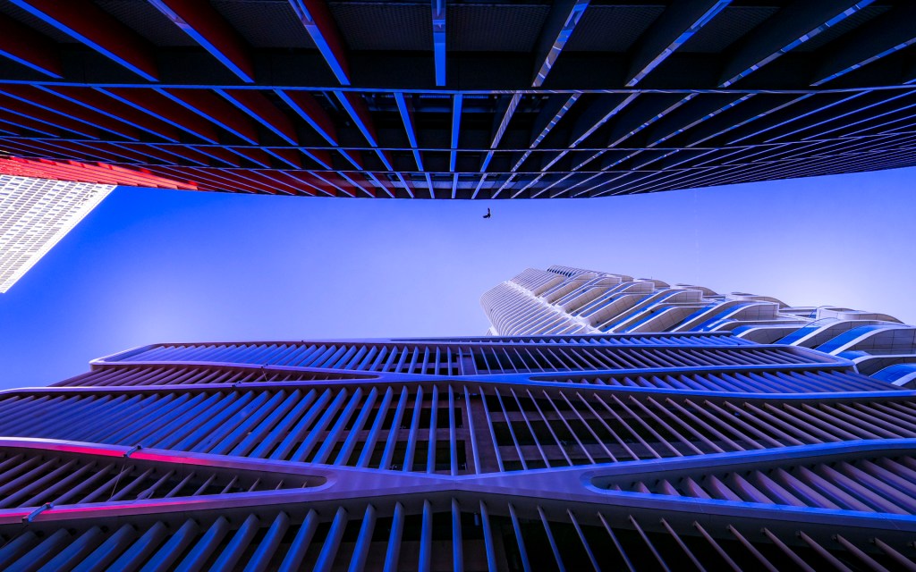 Blick auf den Grand Tower in Frankfurt durch eine Häuserschlucht in blau