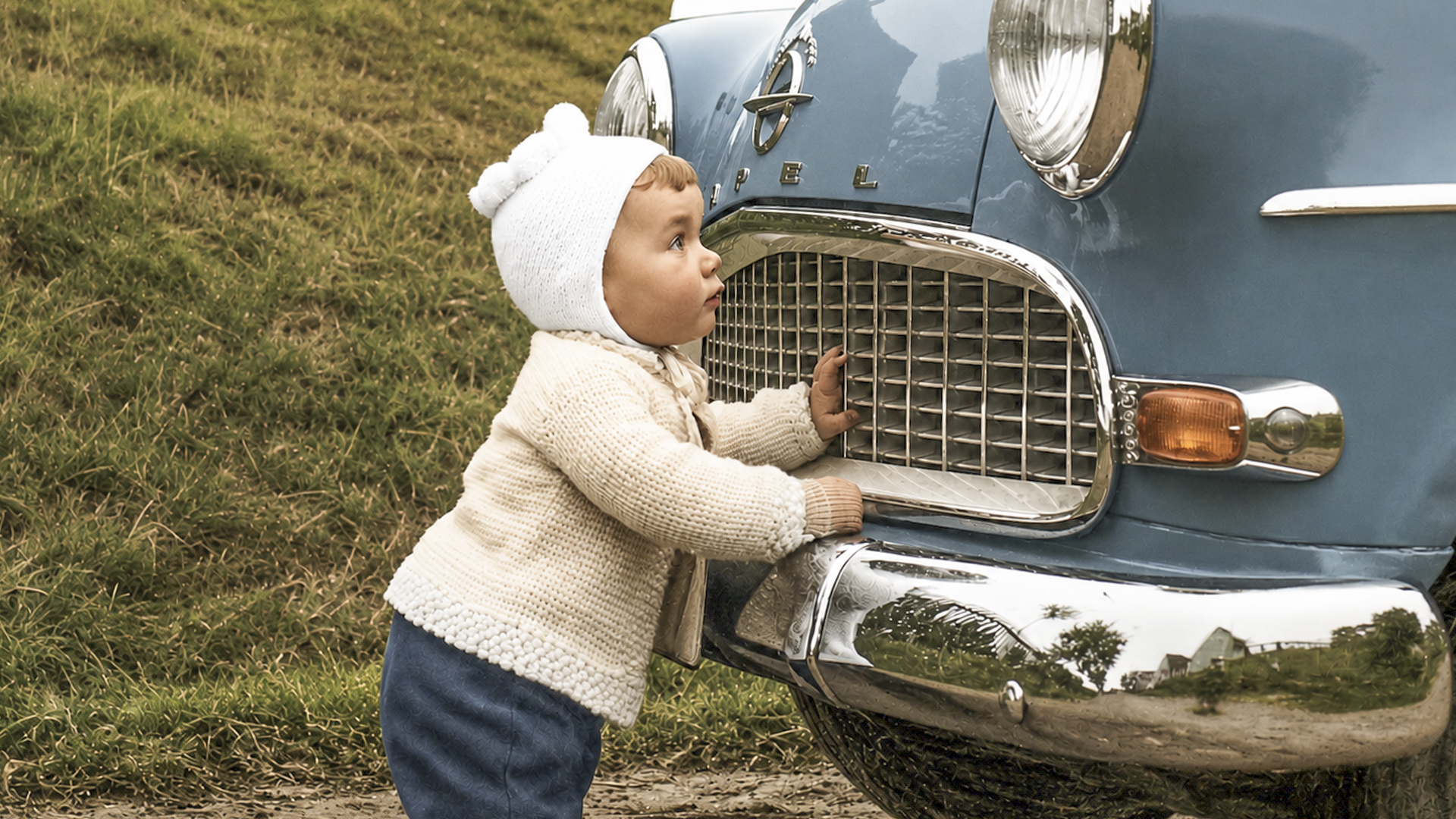 Ein Foto mit einem kleinen Jungen, der vor einem alten Opel steht, vermutlich Ende der 50er Jahre