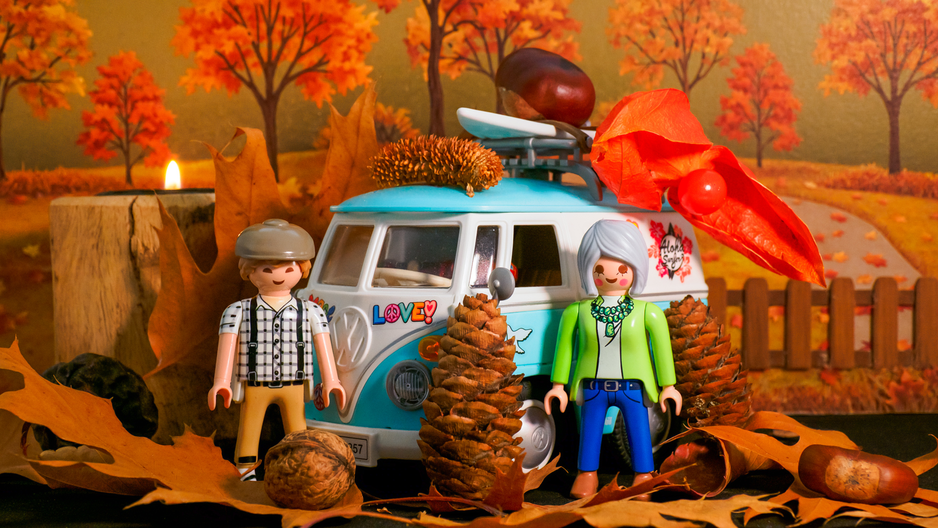 Ein Herbstfoto mit einem Playmobilmodell eines VW Campers, zwei Playmobilfiguren und ein wenig Herbstdeko. Der Hintergrund ist KI generiert.